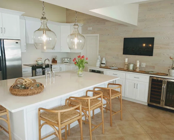 Light kitchen with a white island, cabinetry, and woven counter seating